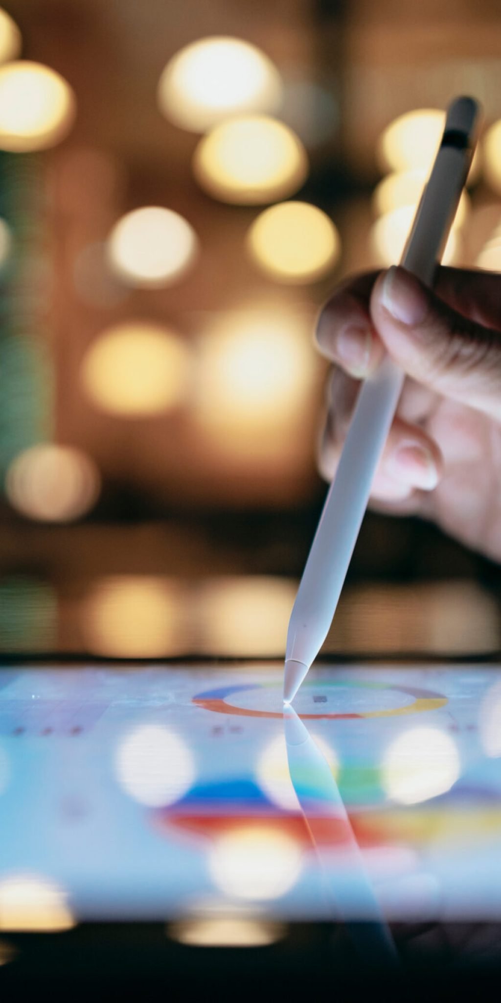 A businessperson is using a stylus to edit work reports on a tablet computer, which, combined with a mobile device, allows them to work more smoothly.